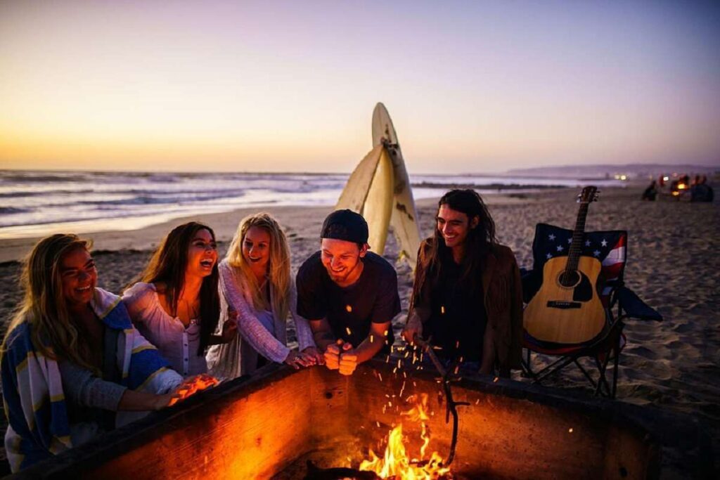 Friends enjoying a beach bonfire at sunset